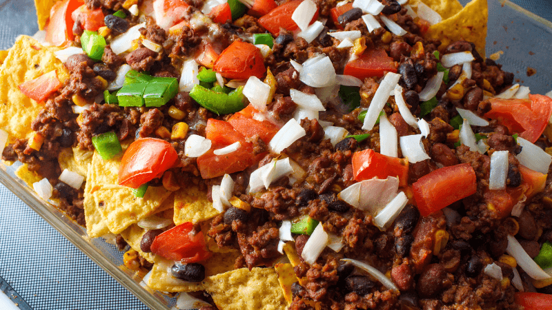 chips layered with cheese, diced tomatoes, onions, grounded beef & beans