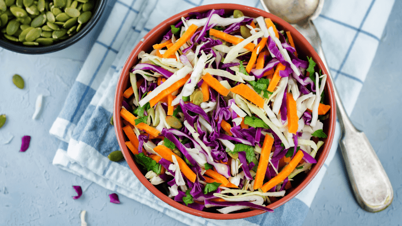 mexican slaw served in a bowl with a spoon aside