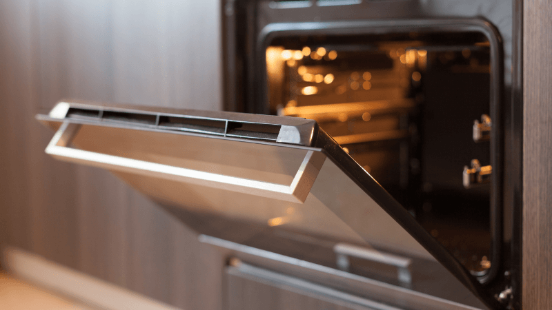 an electric oven with door open & light on